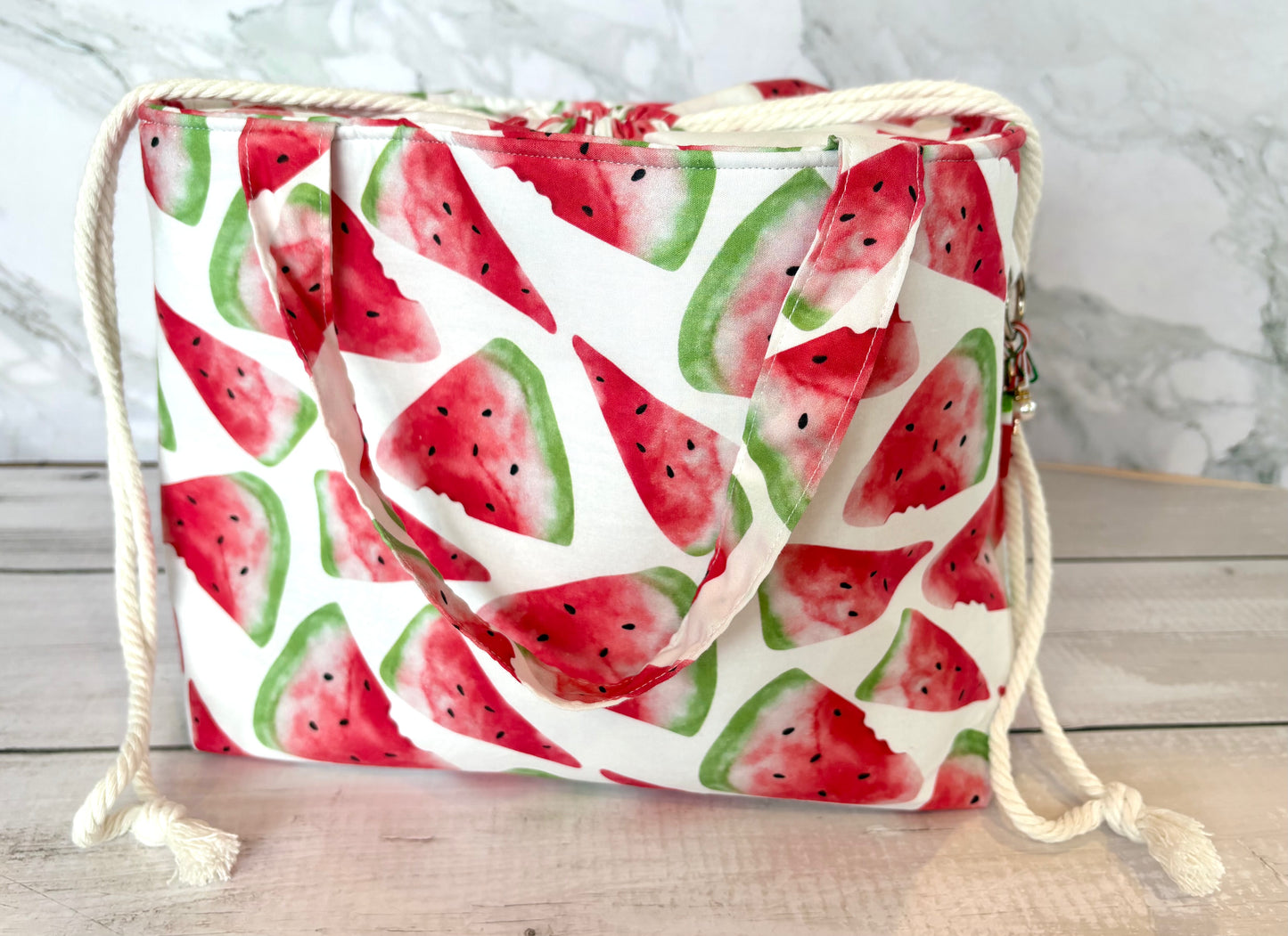 Drawstring bag with watermelon pattern on a wooden surface