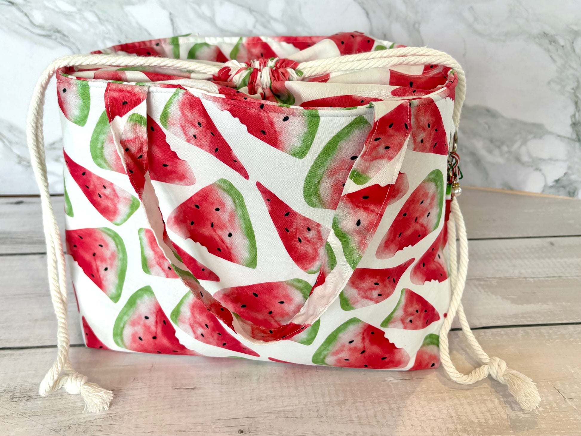Drawstring bag with watermelon pattern on a wooden surface
