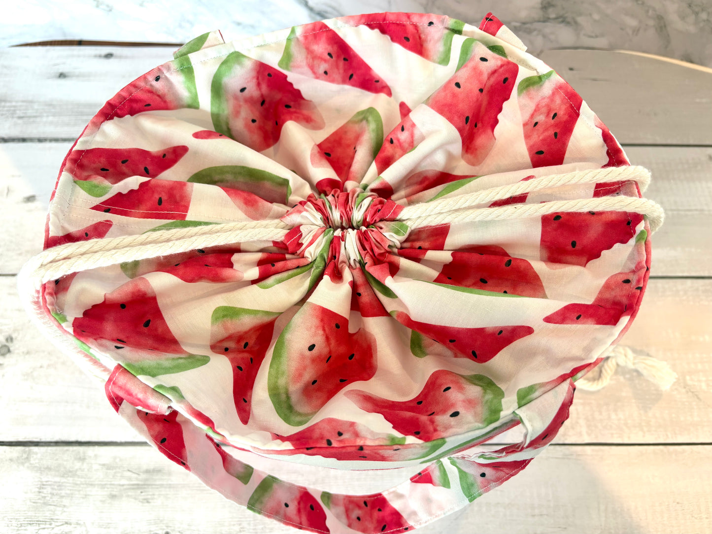 Drawstring bag with watermelon pattern on a wooden surface
