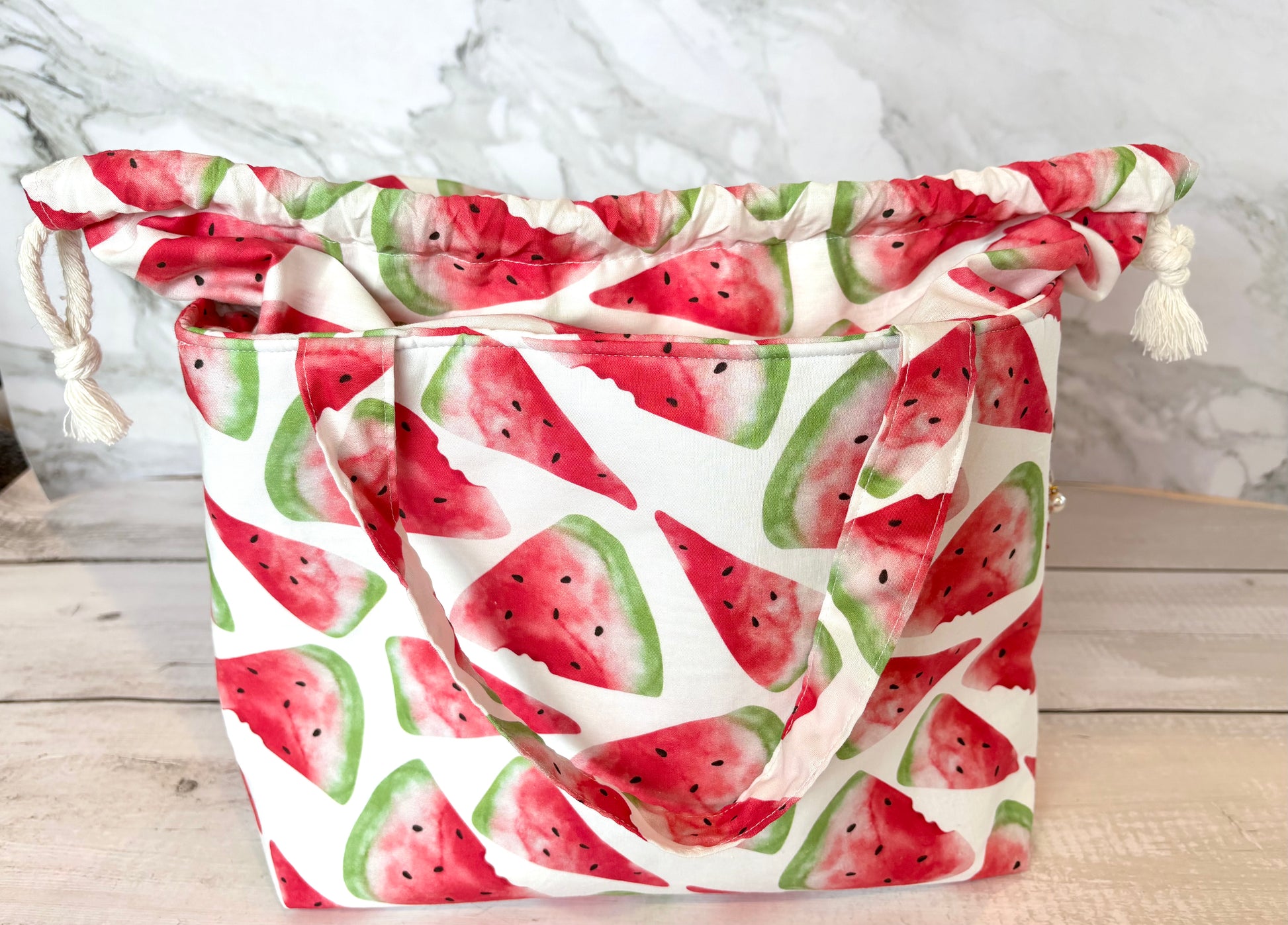 Drawstring bag with watermelon pattern on a wooden surface