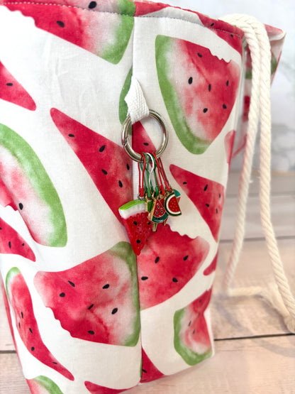 Drawstring bag with watermelon pattern and keychain on a wooden surface